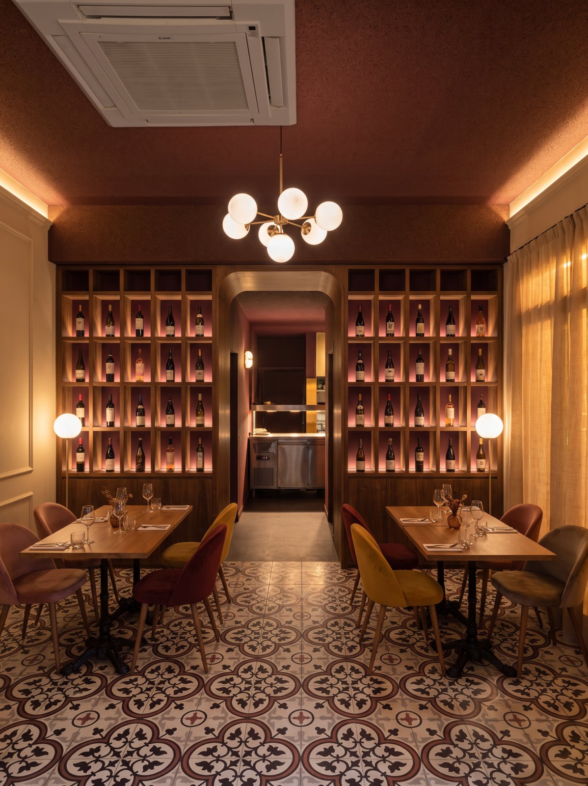 Render del muro de vinos: dos tramos de nichos iluminados con una botella cada uno y paso central redondeado hacia el pase caliente