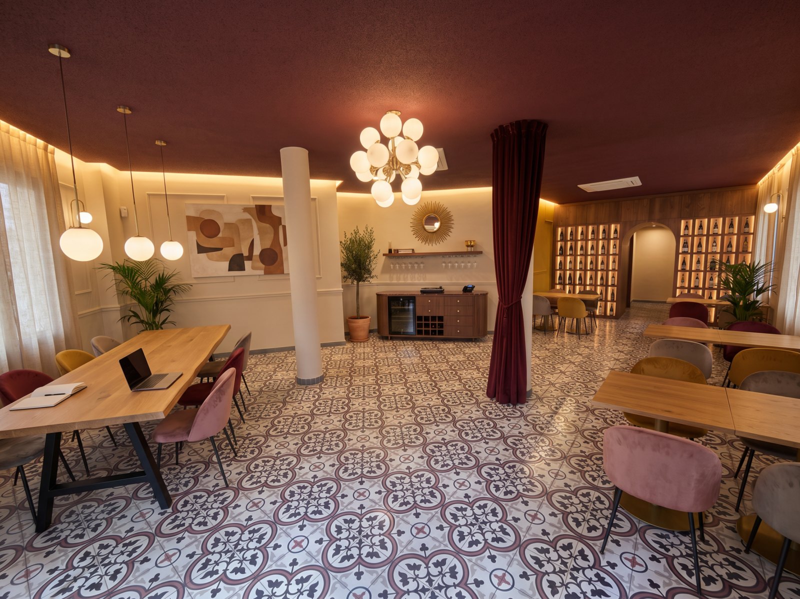 Render de la sala entera: mesa compartida, cuadro, cómoda-recepción, cortina en P1, muro de vinos al fondo y mesas de cuatro